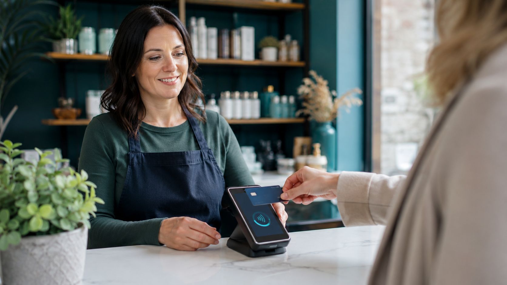 UK business owner accepting a contactless card payment using a Paym8 terminal